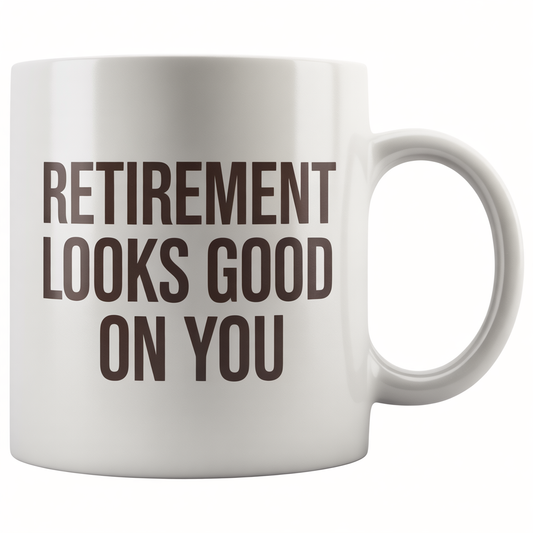 Front view of a white ceramic coffee mug with 'Retirement Looks Good On You' text, perfect happy retirement gift for women.