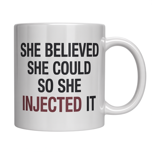 Front view of a white ceramic coffee mug with 'She Believed She Could So She Injected It' text, perfect nurse graduation gift.